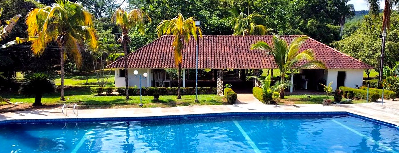Piscina rodeada de palmeras y zonas verdes en un condominio de Melgar, Tolima